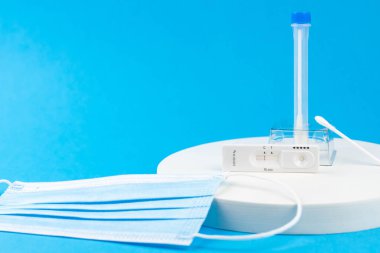 Coronavirus covid 19 için antijen testi yapın. Laboratuvar kartı koronası hızlı test cihazı. Olumsuz sonuç. Burun çubuğu, tüp ve maske takın. 