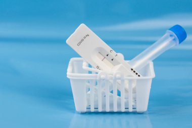 Coronavirus covid 19 için antijen testi al. Laboratuvar kartı koronası hızlı test cihazı. Eczane konsepti. Olumsuz sonuç. Sıhhiye çubuğu, tüp yerleştirin. 