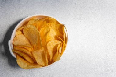 Çıtır tuzlu patates cipsi ya da beyaz arka planda kasede cips. Sağlıksız gıda konsepti.