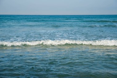 Deniz ya da okyanus manzarası. Güneşin altında deniz dalgaları. Yaz tatili ve seyahat konsepti. Su dalgası yüzeyi. Kumsal. 