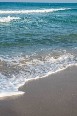 Deniz ya da okyanus manzarası. Güneşin altında deniz dalgaları. Yaz tatili ve seyahat konsepti. Su dalgası yüzeyi. Kumsal. 