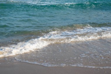Deniz ya da okyanus manzarası. Güneşin altında deniz dalgaları. Yaz tatili ve seyahat konsepti. Su dalgası yüzeyi. Kumsal. 