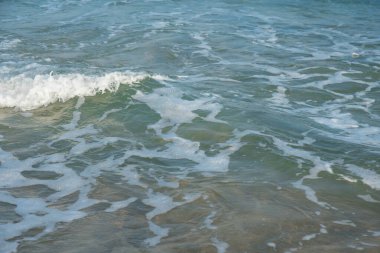 Deniz ya da okyanus manzarası. Güneşin altında deniz dalgaları. Yaz tatili ve seyahat konsepti. Su dalgası yüzeyi. Kumsal. 