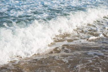 Deniz ya da okyanus manzarası. Güneşin altında deniz dalgaları. Yaz tatili ve seyahat konsepti. Su dalgası yüzeyi. Kumsal. 