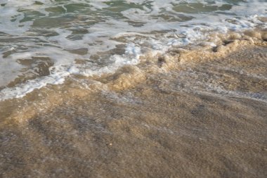 Deniz ya da okyanus manzarası. Güneşin altında deniz dalgaları. Yaz tatili ve seyahat konsepti. Su dalgası yüzeyi. Kumsal. 