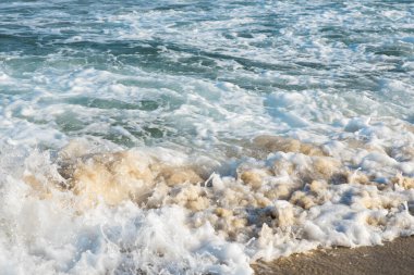 Deniz ya da okyanus manzarası. Güneşin altında deniz dalgaları. Yaz tatili ve seyahat konsepti. Su dalgası yüzeyi. Kumsal. 
