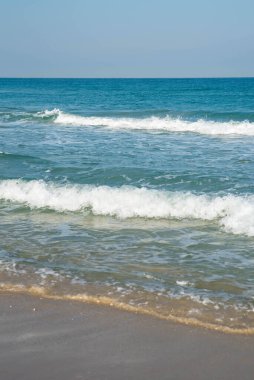 Deniz ya da okyanus manzarası. Güneşin altında deniz dalgaları. Yaz tatili ve seyahat konsepti. Su dalgası yüzeyi. Kumsal. 