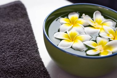 Suyun içinde tesisat çiçekleri olan güzel bir spa kompozisyonu..