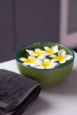 Suyun içinde tesisat çiçekleri olan güzel bir spa kompozisyonu..