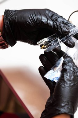 Güzellik salonunda bir müşterisi olan usta manikür ve pedikür dolabında jel rengini seçiyor. Müşteri seçimi için çok renkli oje paletinde farklı oje renkleri var. Tırnak sanatı 