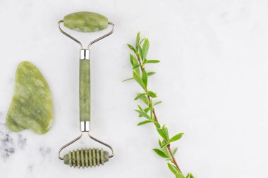 Yüz silindiri ve Guasha masaj aleti. Yüz bakımı ve anti-yaş ürünleri. Çin Gua Sha masaj aletleri gül kuvars. 