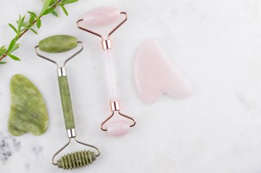 Yüz silindiri ve Guasha masaj aleti. Yüz bakımı ve anti-yaş ürünleri. Çin Gua Sha masaj aletleri gül kuvars. 