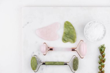 Yüz silindiri ve Guasha masaj aleti. Yüz bakımı ve anti-yaş ürünleri. Çin Gua Sha masaj aletleri gül kuvars. 