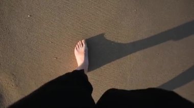 Deniz kıyısında yürüyen insanlar. Deniz ya da okyanus manzarası. Güneşin altında deniz dalgaları. Yaz tatili ve seyahat konsepti. Su dalgası yüzeyi. Kumsal. 