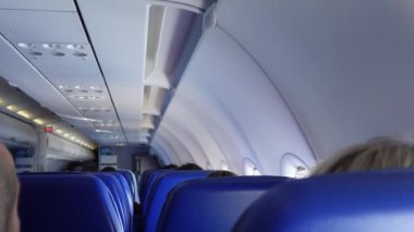 Uçuş ve iniş sırasında uçağın içinde. Corona virüsü maskeli yolcularla dolu sandalyeler