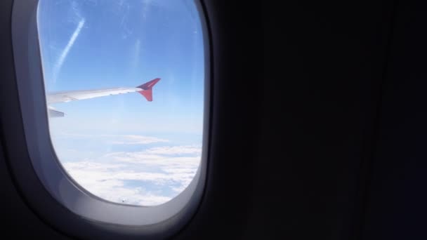 飛行機の便だ 着陸のために 美しい空と雲と土地の日没の間に翼の飛行機の窓からの眺め — ストック動画