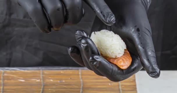 寿司職人の手を閉じて日本料理を準備する レストランで寿司を作る男 伝統的なアジアの魚介類はまな板に転がる — ストック動画