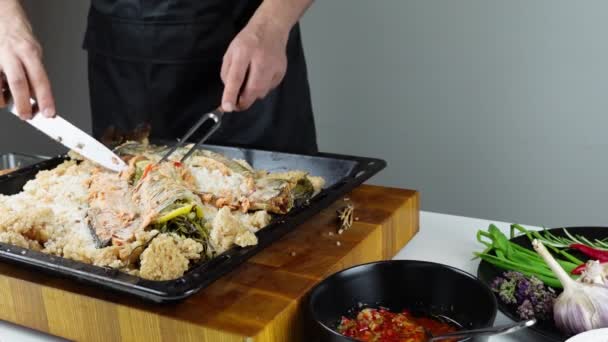 主厨是碎咸鱼和在咸皮上烤的切鱼 海鲜烹调 盐果皮下加蔬菜的鲑鱼或鲈鱼 — 图库视频影像