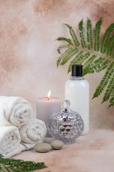 健康中心按摩床上的温泉静物疗法组成 带香味蜡烛的热毛巾 米色背景 芳香疗法设置 平衡与冥想 美的概念 — 图库照片