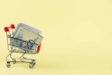 İsrail parası, sarı arka planda alışveriş arabasında para şekel şekel. Değişim Oranları ve para birimi konsepti satın almak.