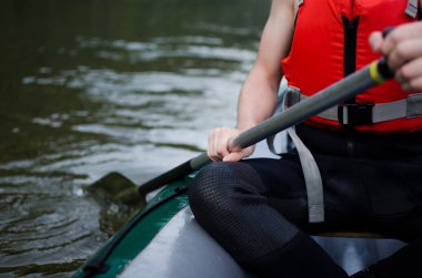 Güvenlik yeleği giyen ve teknede kürek çeken bir adama yaklaş - yaz sporu aktiviteleri