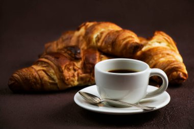 Koyu kahverengi tahtada taze kahve ve lezzetli tereyağlı kruvasanlarla dolu bir hayat.