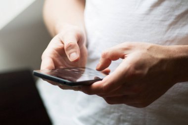 Telefonla mesajlaşan bir adamın ellerine yakın çekim.