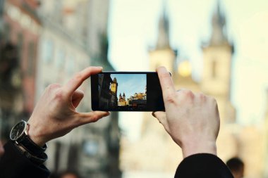 Prag 'ın merkezindeki tarihi binanın fotoğrafını çeken bir adamın elini kapatıyoruz.