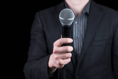 Elinde mikrofon tutan takım elbiseli bir adama yaklaş - konuşma, konferans, röportaj