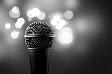Arka planda bulanık ışıklar olan profesyonel bir mikrofonu kapat - parti, konser, karaoke konsepti