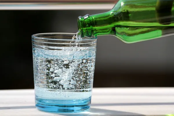 Despejar água mineral no copo Imagens De Bancos De Imagens