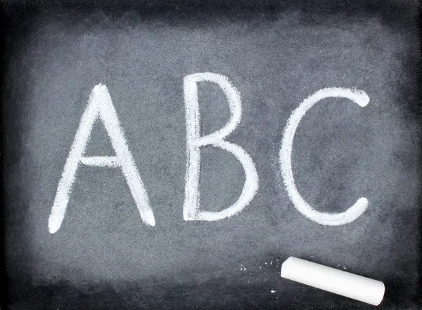 Abc buchstaben und kreide auf tafel — Stockfoto