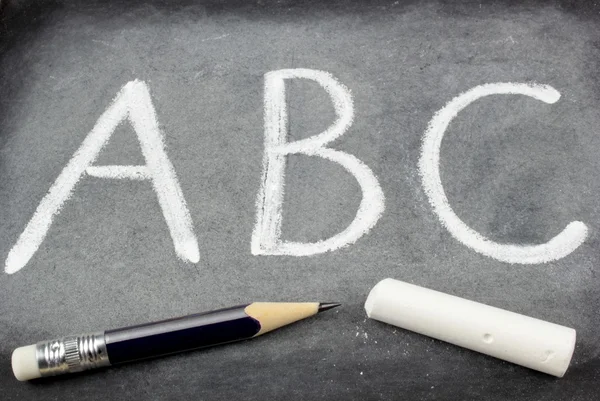 ABC on blackboard, pencil and chalk — Stock Photo, Image