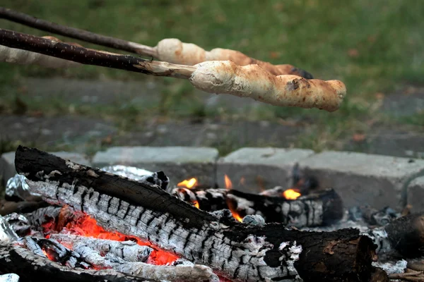 Campfire and bread baking with stick — Stock Photo, Image