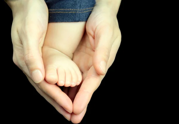 Pie de bebé en manos de madre — Foto de Stock