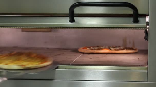 Hornear pizza en el horno — Vídeo de stock