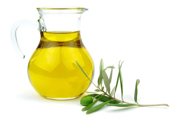 Olive oil in glass carafe and green olive branch — Stock Photo, Image