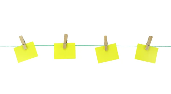 Blank yellow note papers hanging with wood pegs on clothesline. — Stock Photo, Image