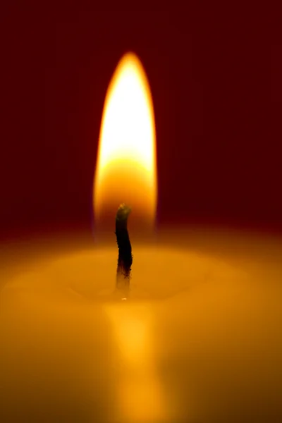 Primer plano de una vela encendida sobre un fondo oscuro —  Fotos de Stock