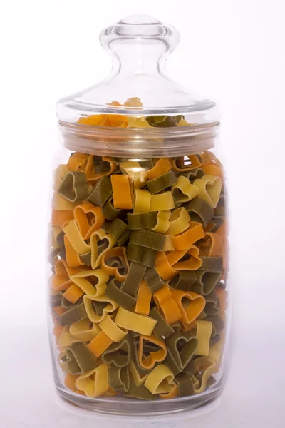 Large pasta in glass jar on a white background Royalty Free Stock Images