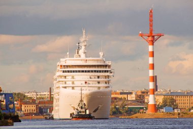 Kar beyazı bir yolcu gemisi sanayi bölgesinde uzun bir yolculuğa çıkar.