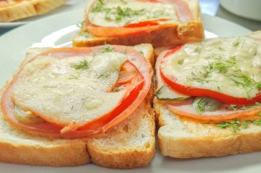 Jambonlu, peynirli ve domatesli sıcak sandviçler.