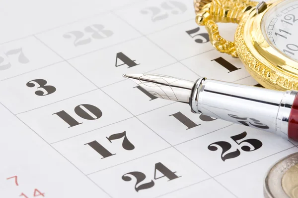 Bläck penna och mynt pengar på kalendern — Stockfoto