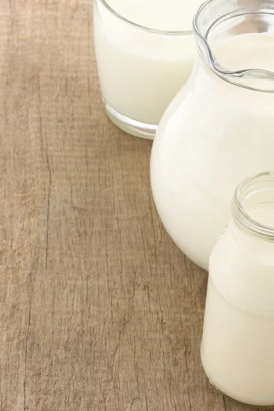 Milk in glass and battle on wood — Stock Photo, Image