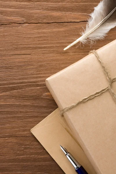 Paquete envuelto con papel marrón sobre madera — Foto de Stock