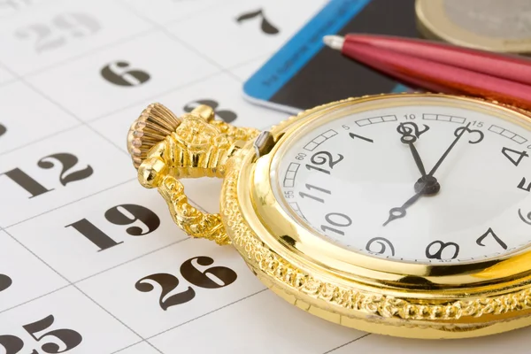 Pluma de tinta y moneda de dinero en el calendario — Foto de Stock