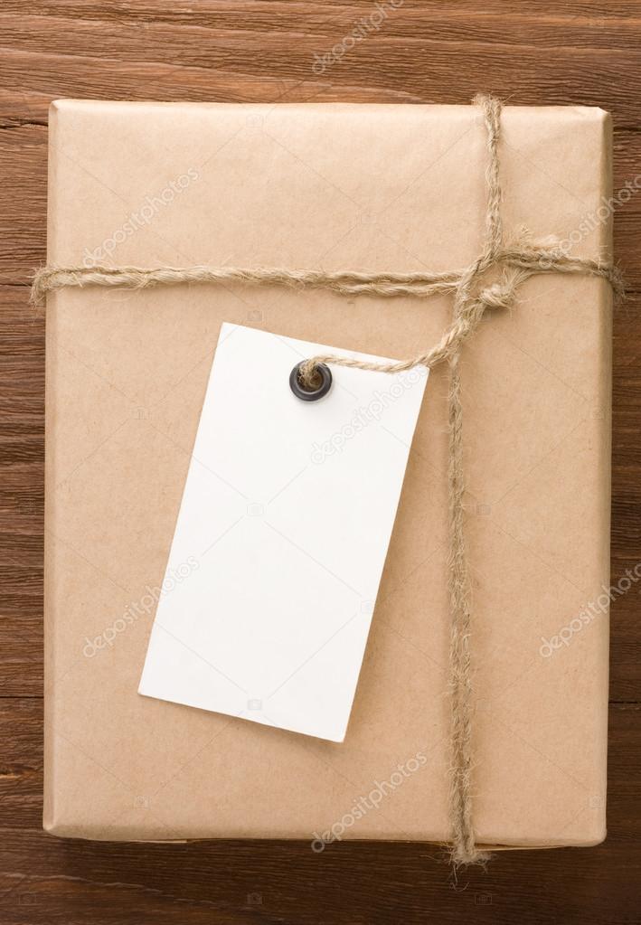 paper parcel wrapped tied with price tag on wood