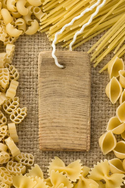 Ruwe pasta en prijskaartje op zak Hessiaan — Stockfoto