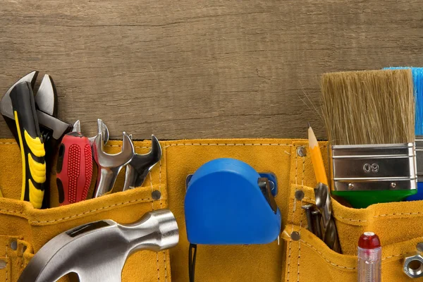 Tools in construction belt on wood — Stock Photo, Image