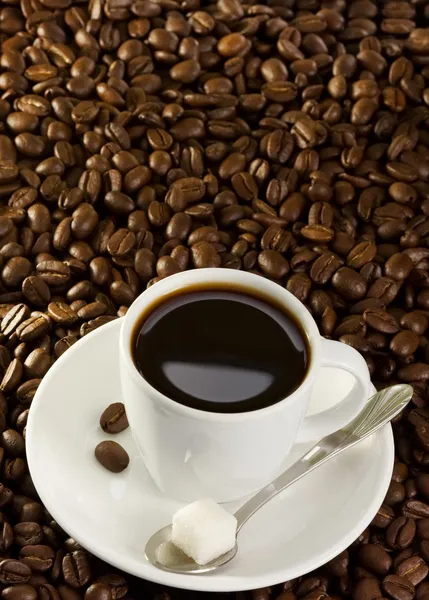 Volle Tasse Kaffee bei Bohnen — Stockfoto